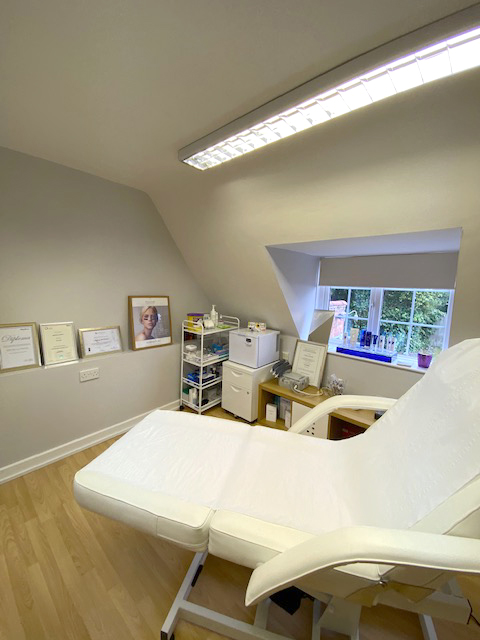 Image of treatment room at Dermedicare aesthetics clinic in Swanland East Yorkshire. Light coloured treatment couch againt neautiful window and tastefully decorated clinical area